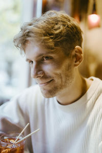 Smiling man wearing nose ring while having drinks at bar