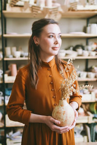 Portrait of young woman standing in store