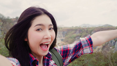 Portrait of happy woman with arms raised