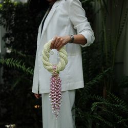 Midsection of woman holding flowers against plants