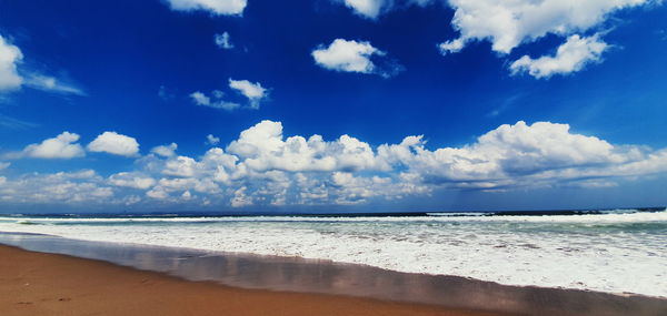 Scenic view of beach against blue sky