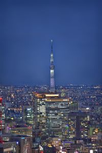 Illuminated buildings in city against sky at night