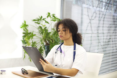 Doctor holding clipboard sitting in clinic