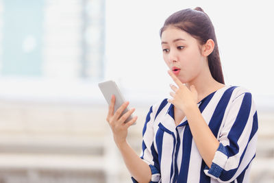 Portrait of young woman using mobile phone