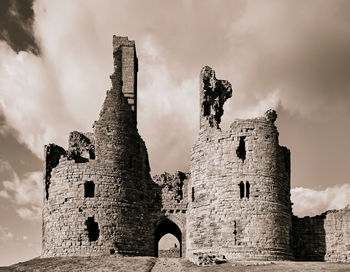 Low angle view of old building against cloudy sky