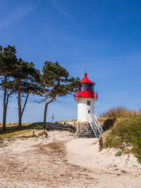 Lighthouse by sea against sky