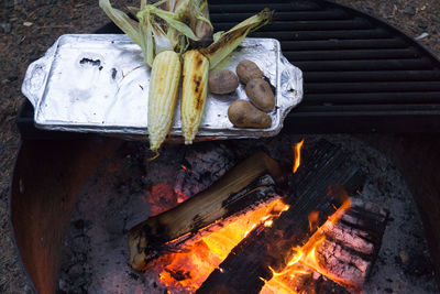 High angle view of corns and potatoes grilling on barbecue