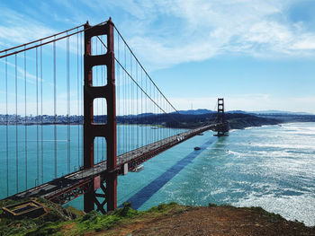 View of suspension bridge against cloudy sky