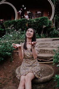 Portrait of a smiling young woman sitting outdoors