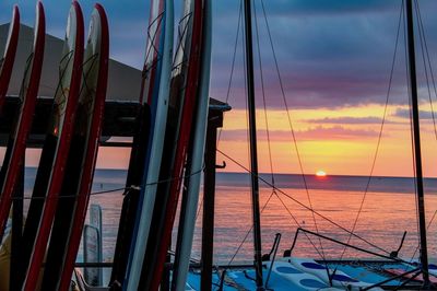 Sailboats sailing on sea against sky during sunset