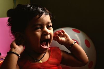 Close-up of cute girl yawning at home