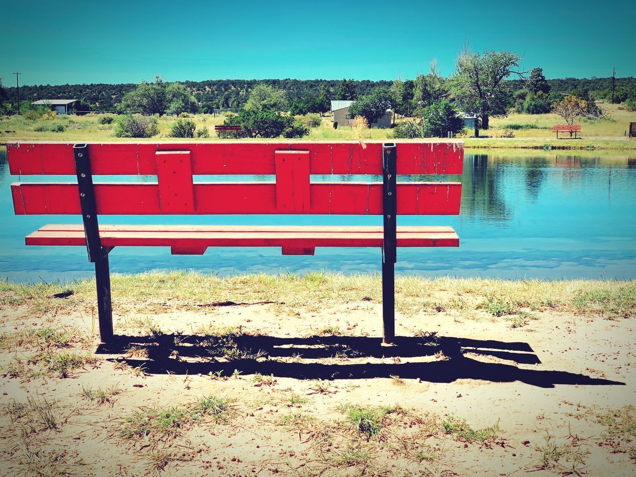 BENCH BY LAKE AGAINST SKY