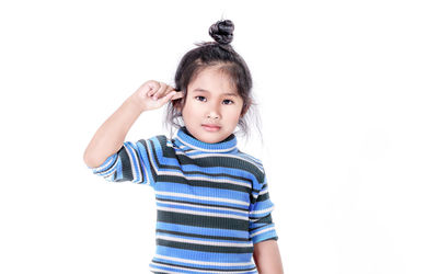 Portrait of cute girl standing against white background