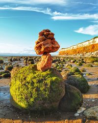 Stack of rocks on shore against sky