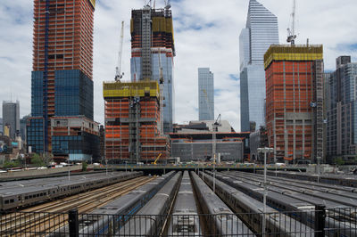 Railroad tracks in city against sky