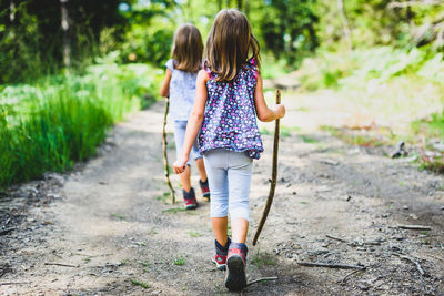 Rear view of girl walking on road