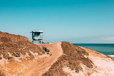 Lifeguard hut on beach against clear sky