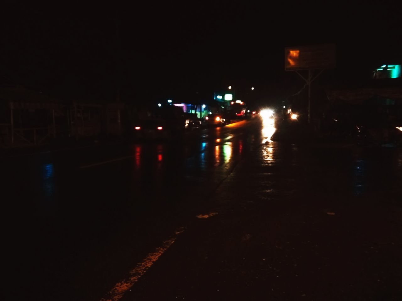 CARS ON ILLUMINATED ROAD AT NIGHT