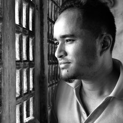 Close-up portrait of young man looking away at home