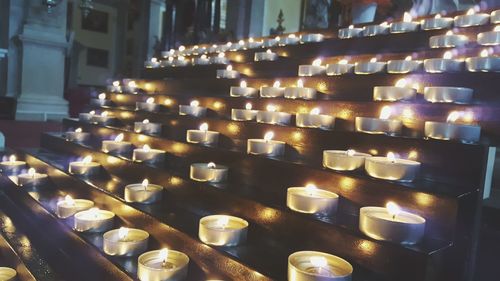 Close-up of illuminated candles in temple