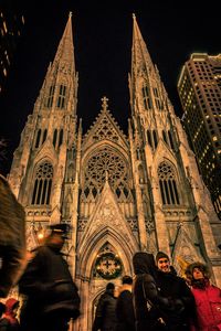 Low angle view of illuminated cathedral against sky at night