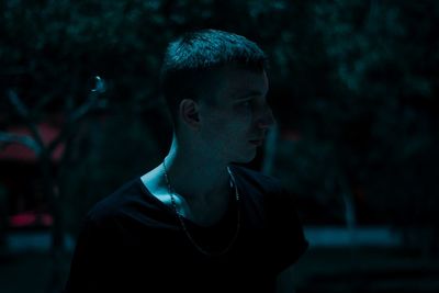 Thoughtful young man looking away outdoors at night