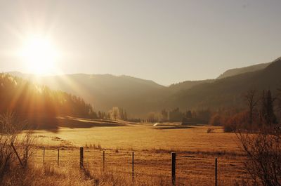 Scenic view of field and mountains against bright sky