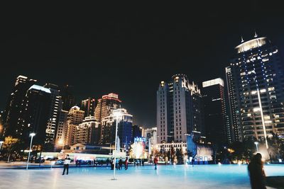 Illuminated city against clear sky at night