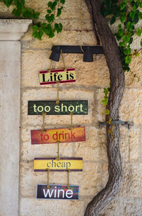 Close-up of sign on tree trunk against wall