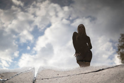 Low angle view of man standing on beach against sky