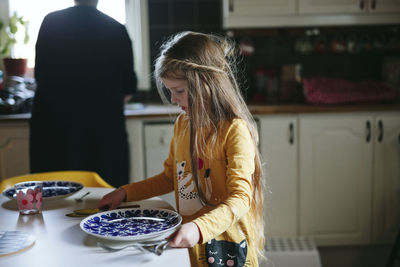 Midsection of woman standing in kitchen at home