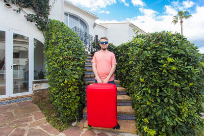 Man wearing sunglasses standing by plants