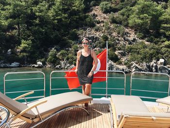 Woman standing by turkish flag in boat on sea