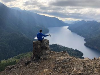 Man sitting on rock while feeding bird