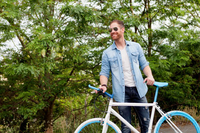 Young man riding bicycle on tree