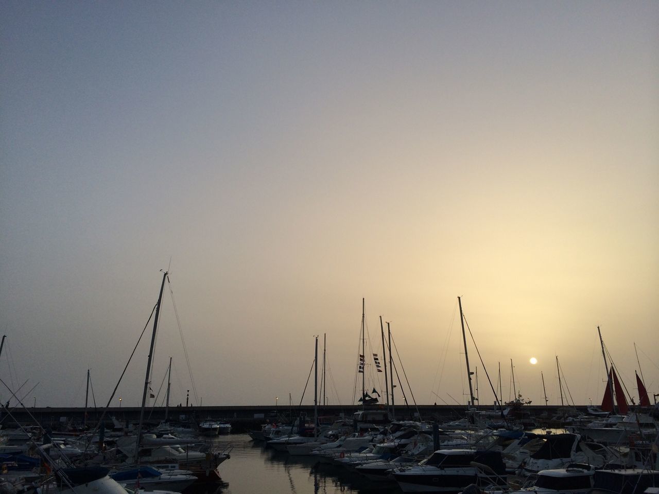 nautical vessel, transportation, mode of transport, moored, boat, water, mast, harbor, sea, sailboat, clear sky, copy space, sunset, nature, travel, sky, outdoors, no people, tranquility, beauty in nature