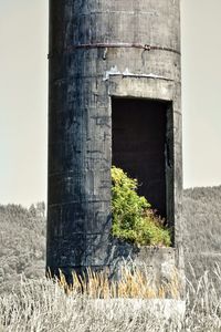 Old abandoned building on field against sky