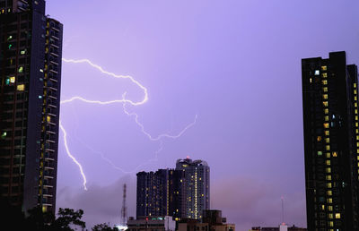 Low angle view of illuminated buildings against sky at night