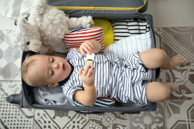 Baby playing with toys in suitcase