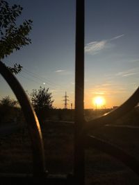 Silhouette trees on field against sky during sunset