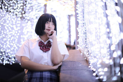 Portrait of teenage girl standing against wall