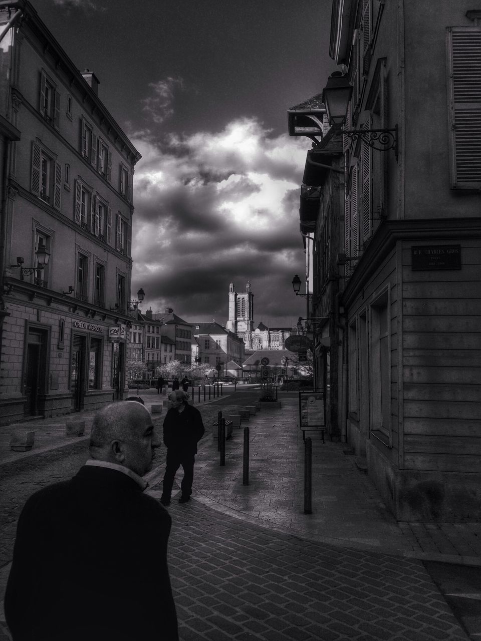 building exterior, architecture, built structure, city, sky, men, street, walking, the way forward, lifestyles, cloud - sky, residential building, rear view, city life, building, residential structure, person, cloud