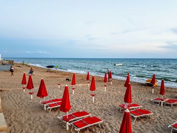 Chairs on beach against sky