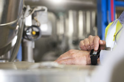 Man using smartwatch in industrial plant