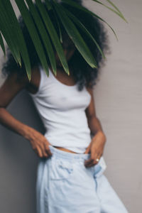 Rear view of woman standing against wall