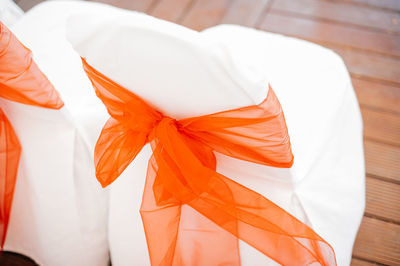 Orange satin bow tied on chair