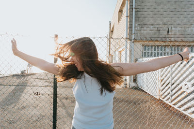 Rear view of woman standing against wall