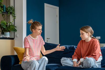 Excited mother spread arms while talk to teen daughter, ignoring misunderstanding of transition age