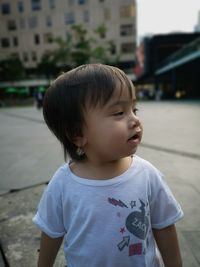 Cute baby boy standing in city