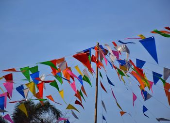 Low angle view of flags against clear blue sky